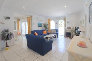 エンプリアブラバにあるLEON INMO Villa Franca - 10049のリビングルーム(青いソファ、テーブル付)