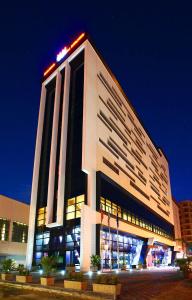 a large white building with lights on top of it at Hotel Partner in Vlorë
