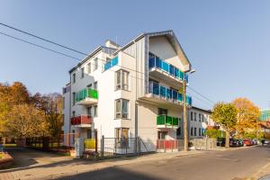 a white building with colorful balconies on a street at Kolorowe Balkony II by Renters in Międzyzdroje