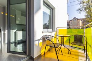 a balcony with two chairs and a table at Kolorowe Balkony II by Renters in Międzyzdroje