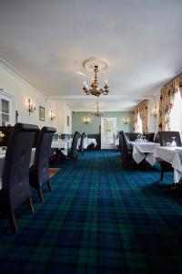 a dining room with tables and chairs and a chandelier at Best Western The George Hotel, Swaffham in Swaffham