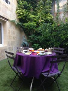 a table with a purple table cloth sitting on a lawn at Les Chambres d'Art in Bordeaux