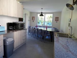 a kitchen with a table with chairs and a microwave at Villa Violaine in Sassetot-le-Mauconduit