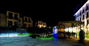 a night view of a courtyard with a table and chairs at Elegant Hotel & Resort in Tsaghkadzor