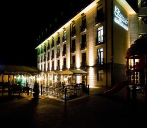 a lit up building with tables and chairs at night at Elegant Hotel & Resort in Tsaghkadzor