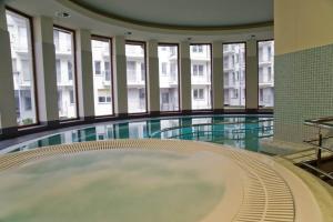 a large swimming pool in a building with windows at Apartament Charisma in Zakopane