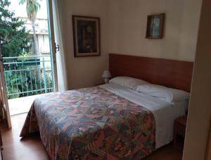 a bedroom with a bed and a large window at Hotel Lucciola in Bordighera