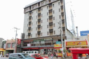 a tall building on a busy city street with cars at RedDoorz @ MJ Cuenco Avenue Cebu in Cebu City