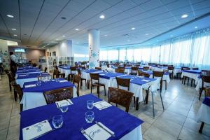 a dining room with blue and white tables and chairs at GH Campoverde Village in San Cataldo