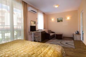 a bedroom with a bed and a desk and a chair at Hotel Tropics & Venera - Ultra All Inclusive in Sveti Vlas