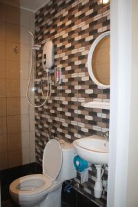 a bathroom with a toilet and a sink at Cozy Riverside Hotel in Melaka