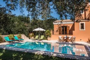 a pool with chairs and a house in the background at Mastrogiannis Villa Levanda in Kavvadádes +46 photos