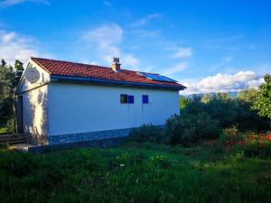 a small white building with a red roof at Ecohouse Oliveglia in Šilo
