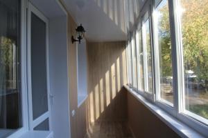 a hallway with windows and shadows on the wall at Apartment on Potanina 16 in Ustʼ-Kamenogorsk