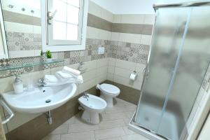 a bathroom with a sink and a toilet and a shower at Case Vacanza Via Mozart in Porto Cesareo +56 photos