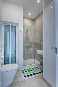 a bathroom with a shower and a toilet and a tub at Modern Seaview Apartment In a Prime Location in Sliema