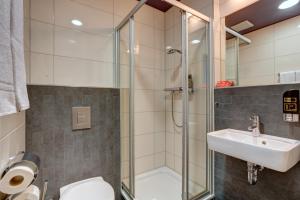 a bathroom with a shower and a toilet and a sink at MEININGER Hotel Wien Downtown Sissi in Vienna