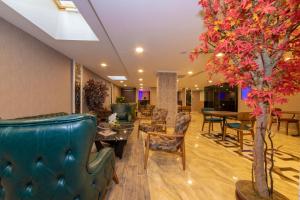 a lobby with furniture and a tree in the middle at Vision Deluxe Hotel in Istanbul