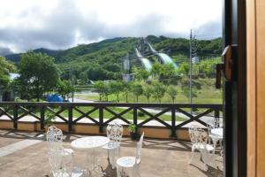 a table and chairs on a balcony with a roller coaster at Hakuba Yamano Hotel in Hakuba