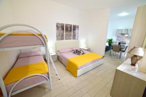 a bedroom with two bunk beds and a kitchen at Case Vacanza Via Mozart in Porto Cesareo