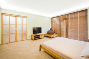 una camera con un grande letto e una TV di Art Hotel KOKTEBEL APARTMENTS a Koktebel
