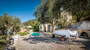 a table in front of a house with a pool at Mastrogiannis villa Dafne in Kavvadádes