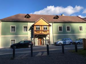 a large green building with cars parked in front of it at Witrich apartman in Murau