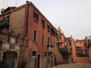un ancien bâtiment en briques rouges dans une ruelle dans l'établissement Locazione Turistica Corte Vecchia, à Venise