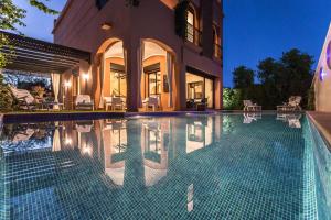 a swimming pool in front of a house at VILLA ILYANA in Marrakesh
