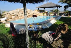 una mesa y sillas junto a una piscina en Casa Entre Armonías, en Zahara de los Atunes