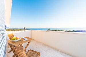 a balcony with a table and chairs and the ocean at Villa Stani, luxury villa with a pool in Novalja