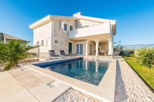 a villa with a swimming pool in front of a house at Villa Stani, luxury villa with a pool in Novalja