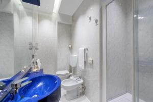 a bathroom with a blue sink and a toilet at Mastino Rooms in Verona