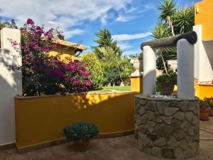 a yellow fence with flowers and plants on it at Casa Entre Armonías in Zahara de los Atunes