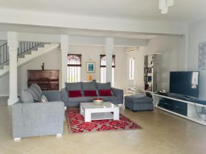 a living room with a couch and a tv at Luxury Villa L'ile Maurice in Pointe aux Cannoniers