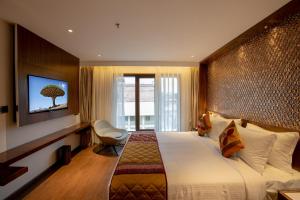 a hotel room with a large bed and a television at Hotel Span International in Cochin