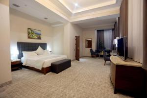 a hotel room with a bed and a flat screen tv at Parliament Palace Hotel in Khujand