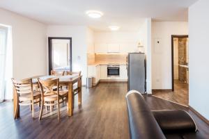 a kitchen and dining room with a table and chairs at Mami Style Apartments in Podtureň