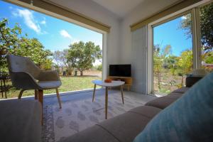 a living room with a couch and a table and a large window at Cap Heureux Villas in Cap Malheureux