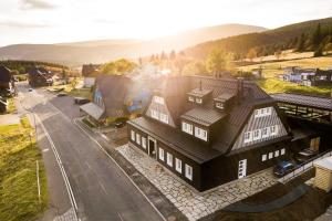 un bâtiment avec un toit noir dans une rue dans l'établissement Chata Hradečanka, à Horní Malá Úpa