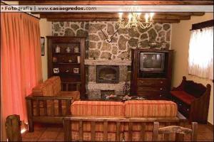 uma sala de estar com um sofá e uma lareira em Casa Rural Las Eras de Riofrio em Ríofrío
