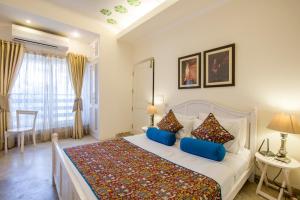 um quarto com uma cama grande e almofadas azuis em Colonel's Retreat 2 em Nova Deli