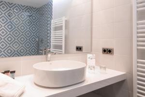 a white bathroom with a sink and a mirror at RVHotels Nieves Mar in L'Escala