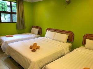 a room with two beds with a teddy bear on them at Hotel dan Restoran Seri Kangsar in Kuala Kangsar