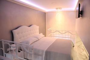 een slaapkamer met een wit bed en een kroonluchter bij Casa D'Amore in Napels