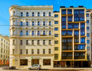 een gebouw waar een auto voor geparkeerd staat bij H+ Hotel Wien in Wenen