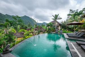 a swimming pool in front of a villa at Arta Nadi Villa in Sidemen