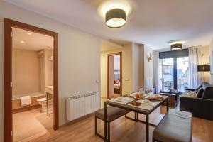 ein Wohnzimmer mit Tisch und Couch in der Unterkunft Pierre & Vacances Andorra El Tarter in El Tarter
