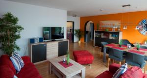 a living room with a red couch and a table at Ferienwohnung Nickmann im Scheffelhof in Bad Säckingen