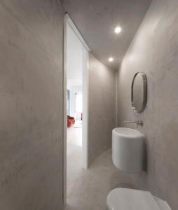 a white bathroom with a sink and a mirror at Awarded 3 bedrooms upscale flat@Chiado Bairro Alto in Lisbon